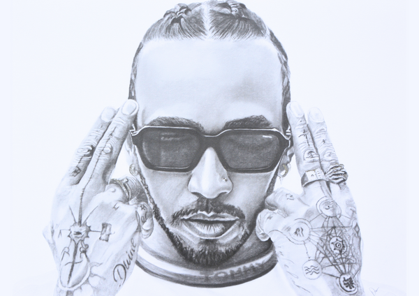 Dean Coldham’s graphite portrait of Lewis Hamilton distills presence into pure monochrome intensity. With hands raised to his temples and eyes hidden behind dark lenses, Hamilton appears composed, focused, and unshakable. Intricate tattoos and finely rendered textures add depth, capturing both the precision and individuality that define a champion.